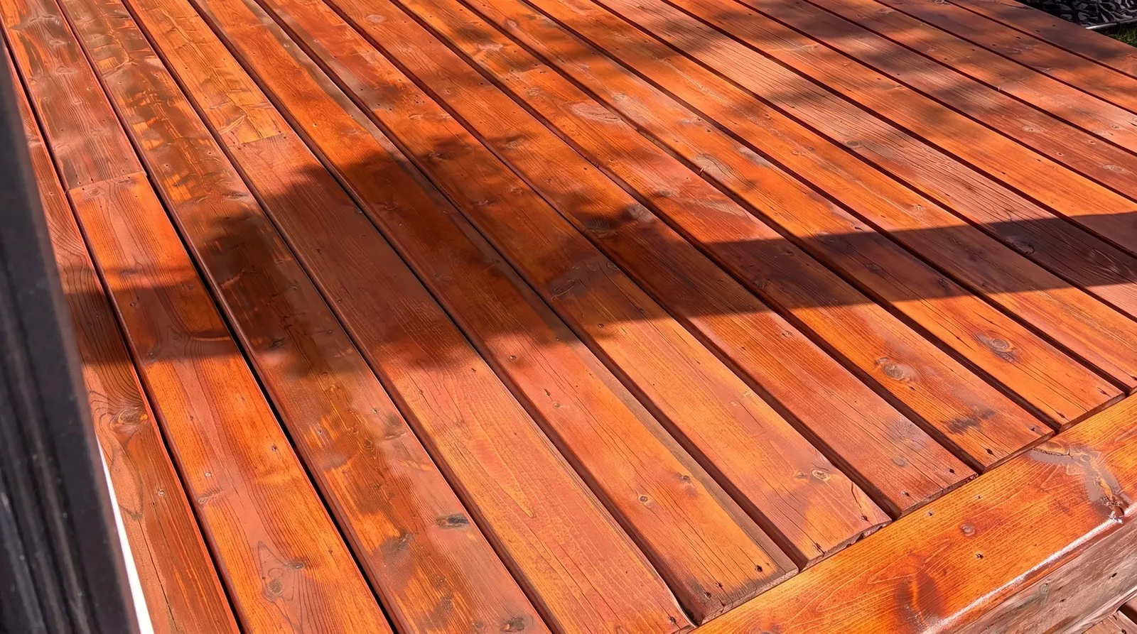 Close view of stained cedar deck boards in low sun