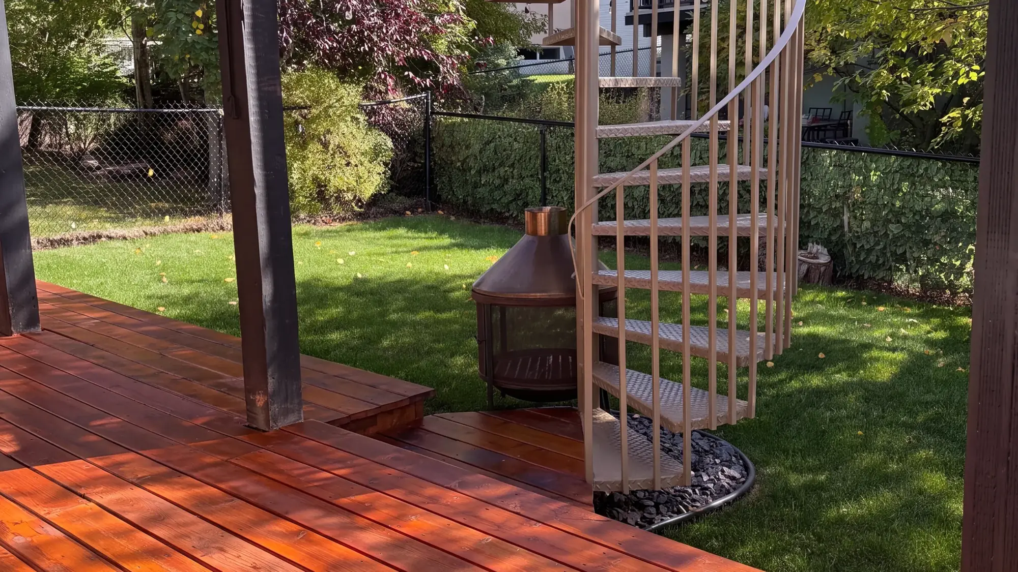 A freshly stained cedar deck beside a spiral staircase